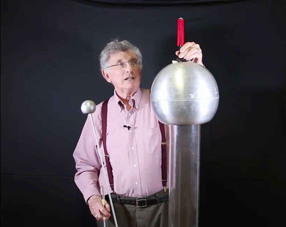 Dr. Bassichis holding up a demonstration for Coulomb's Law